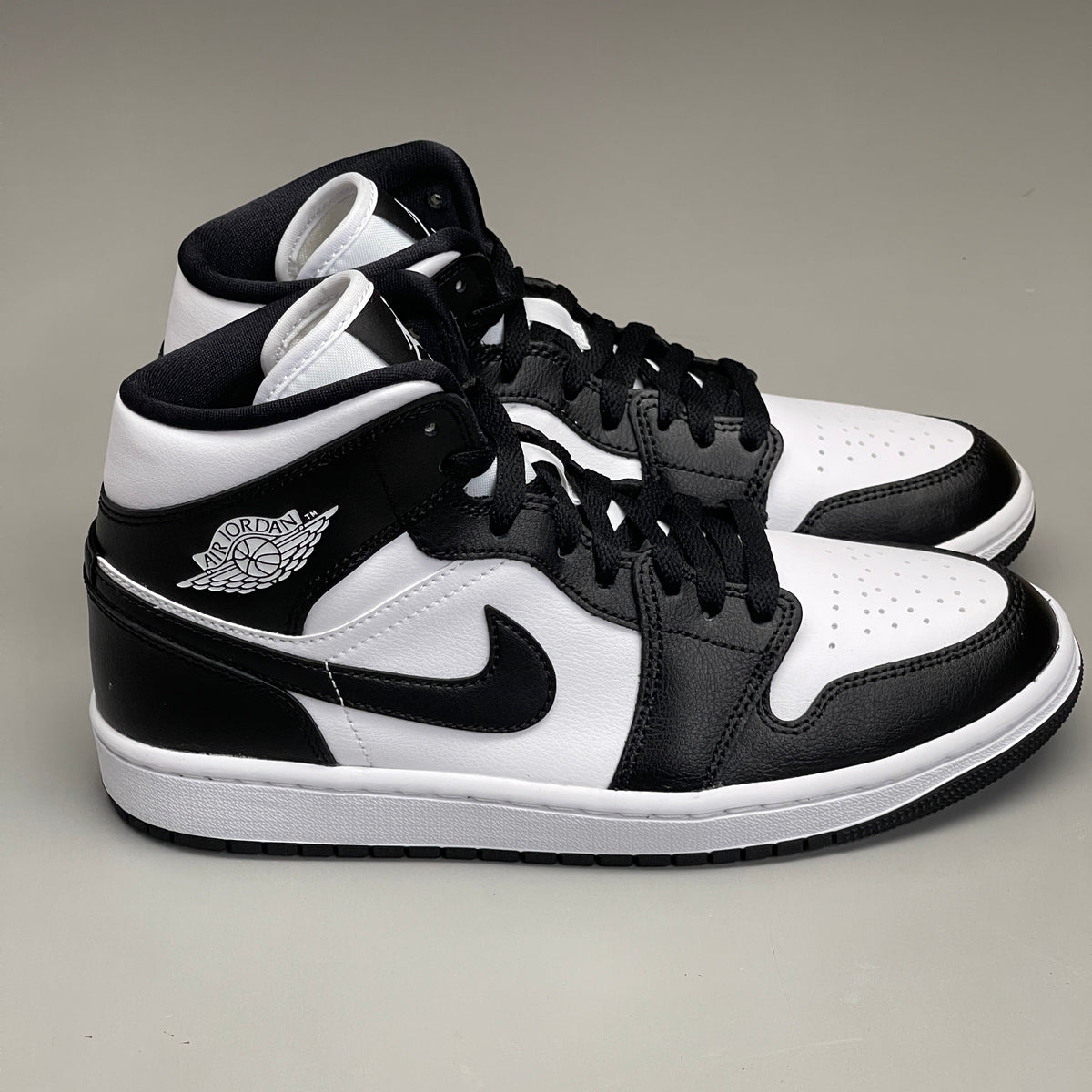 Women's Nike Air Jordan 1 Mid Panda sneakers in black and white, size 6, featuring a stylish design and iconic branding.