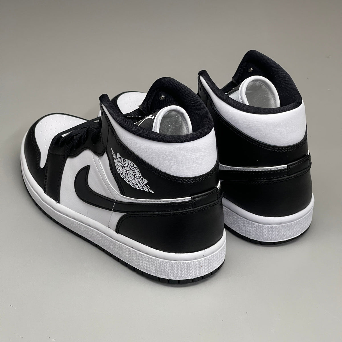 Nike Air Jordan 1 Mid Panda women's sneaker in black and white, featuring a classic design and high-top silhouette.