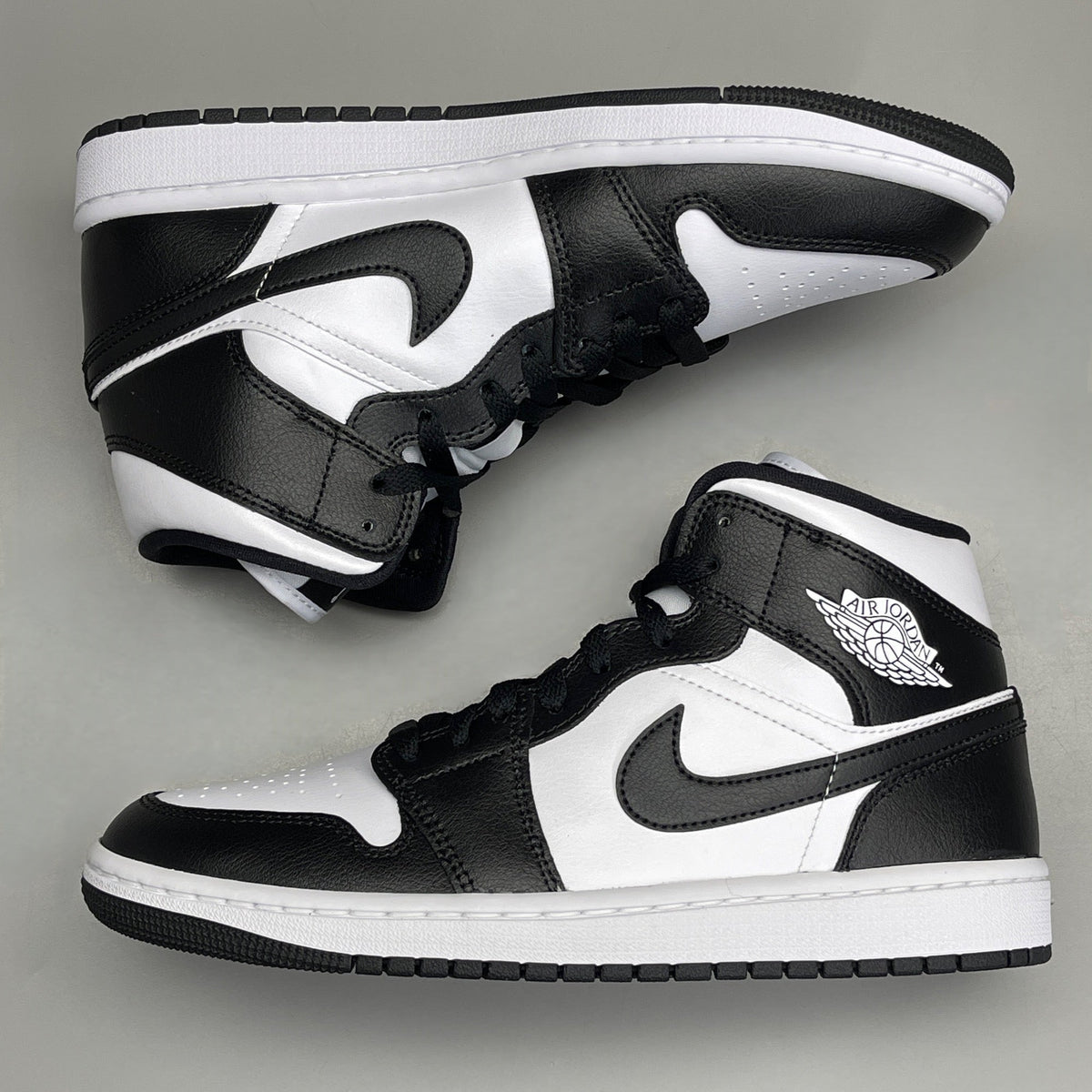 Women's Nike Air Jordan 1 Mid Panda sneakers in black and white, size 6, featuring a classic design and iconic style.