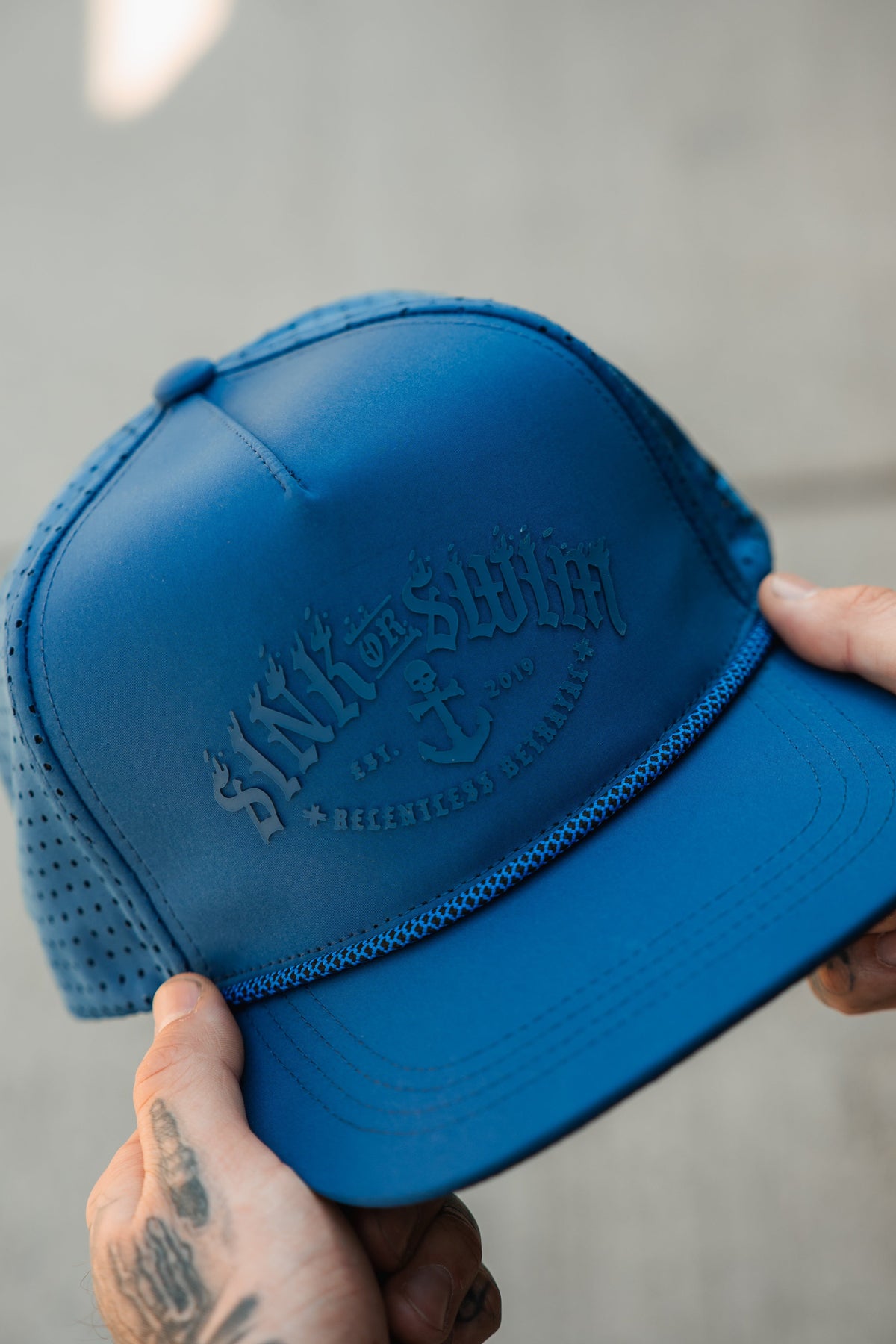 Relentless Betrayal Dark Waters SOS Mute PVC snapback hat with black and dark blue design and adjustable snap closure.