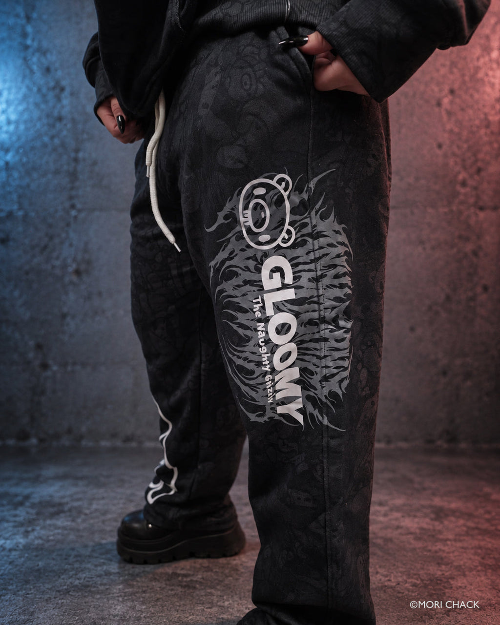 Gloomy lifestyle photo of Brawl Women's Sweatpants by Any Means Necessary Clothing, showing relaxed fit and dark gray fabric.